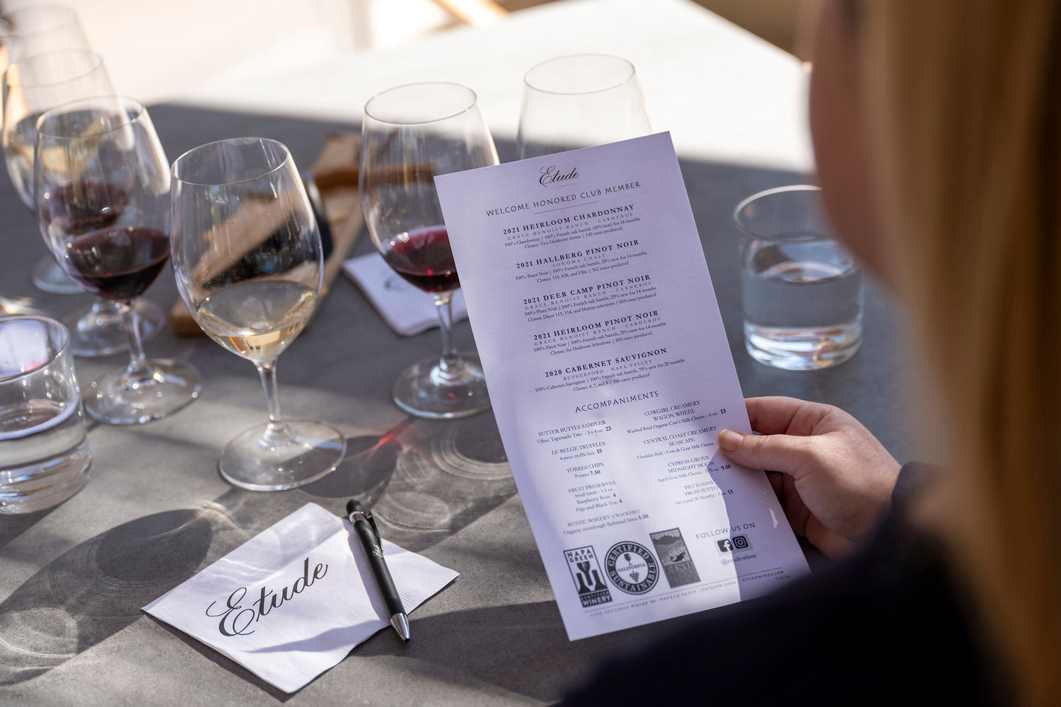 Wine tasting notes and glasses of Chardonnay and Pinot Noir at Etude winery.