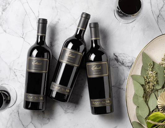 Three bottles of Etude Wines, Cabernet Sauvignon, vintage 2017, on marble surface.