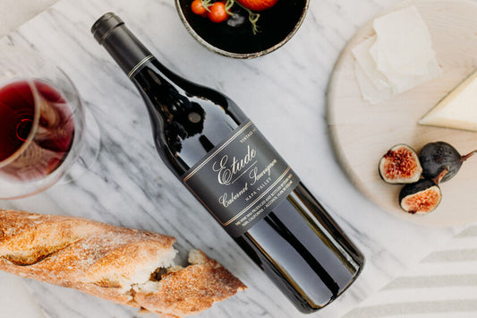 Bottle of Etude Cabernet Sauvignon wine with cheese, bread, and figs.