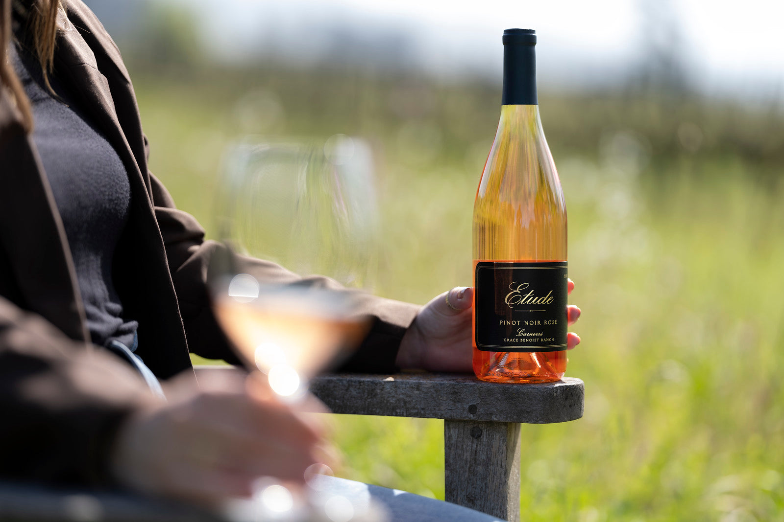 Woman holding a bottle of Etude Pinot Noir Rosé wine.