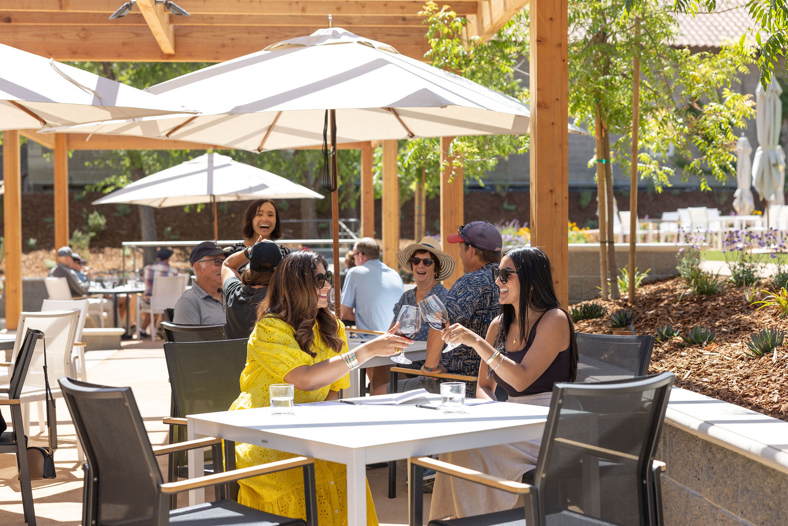 Two women toast with wine on the Etude patio